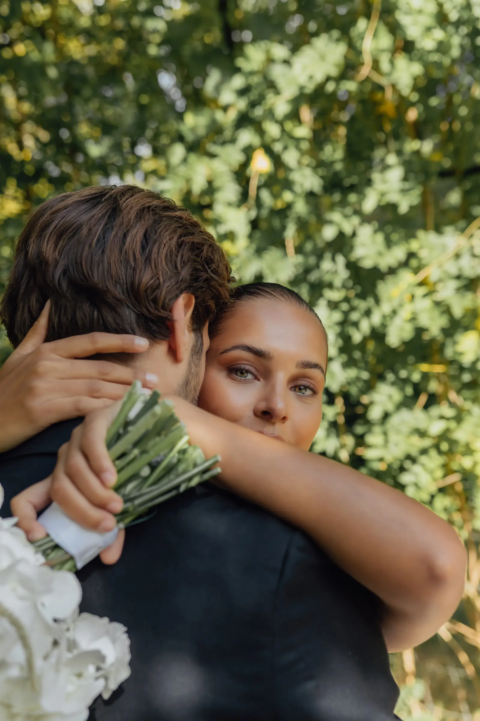 Omhelzing, bruid kijkt over de schouder